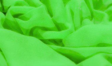 İnce kıvrımlı ve kıvrımlı canlı yeşil bir kumaş, akıcı ve yumuşak bir doku yaratıyor. Işık, karmaşık ağ yapısını vurgular, kumaşa neredeyse parıltılı bir görünüm verir..