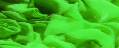 Canlı yeşil kumaş bulanıklığı yumuşak, hafif dokusunu nazik kıvrımlarla sergiliyor. Saf materyal bir ışık ve gölge oyunu yaratıyor, narin ve havadar bir görünüm sunuyor..