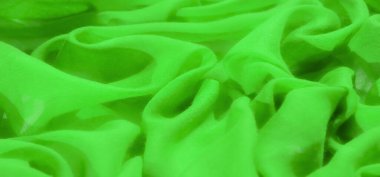 Bulanık yeşil kumaş zarif kıvrımlar ve pürüzsüz kıvrımlar oluşturur. Canlı ve canlı yeşil renk, dinamik soyut arkaplan yaratmak için mükemmel derinlik ve enerji ekler..