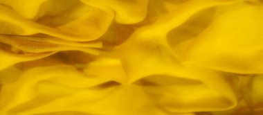 Sarı kumaş bulanıklığı dinamik, akışkan şekiller ve karmaşık kıvrımlar oluşturuyor. Yumuşak doku, ışık ve gölge oyunuyla güçlenir. Canlı ve soyut bir görsel deneyim sunar..