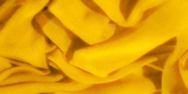 Dalgalanan dalgalı, yumuşak sarı kumaşlı bulanık kumaş. Yakından bakıldığında kumaşın pürüzsüz dokusu ve canlı rengi vurgulanıyor, hem zarif hem de dinamik soyut bir görüntü yaratıyor..