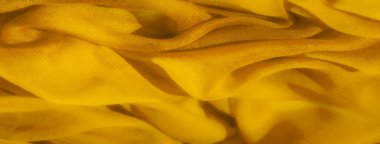 Zengin sarı kumaş bulanıklığı yumuşak kıvrımlar ve dalgalardan oluşan bir deniz yaratıyor. Kumaşın yumuşak dokusu ve şekillerin soyut dizilişi canlı ama sakin bir görsel deneyim sağlar.