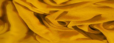 Sarı kumaşın bulanık görüntüsü ince dokusunu ve şeffaflığını sergiliyor. Katların soyut deseni sarı tonlarda dinamik ve canlı bir bileşim yaratır.