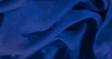 Derin mavi kumaş kıvrımları dalgalı, yumuşak kıvrımlara dönüşüyor. Işık ve gölge etkileşimi narin ağ benzeri dokuya derinlik verir, soyut ve sakin bir görünüm yaratır..