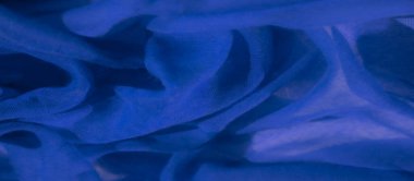 Mavi kumaş bulanıklığı akıcı ve doğal bir ritimle karmaşık kıvrımlar oluşturuyor. Işık yumuşakça kumaşın yüzeyiyle etkileşime girer ve soyut tasarımın ince detaylarını ortaya çıkarır..