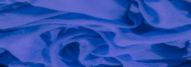 Yumuşak mavi kumaş bulanıklığı yumuşak kıvrımlar ve akışkan dokular oluşturuyor. Kumaşın narin örgüsü ışıkla çok güzel etkileşime girer, rahatlatıcı ve soyut bir kompozisyon yaratır..