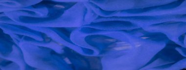 Mavi kumaş bulanıklığı soyut dalgalara doğru kıvrılıyor. Ağ dokusu derinlik yaratırken ışık kıvrımlara boyut ekler ve yumuşak, akışkan soyut bir tasarım oluşturur..