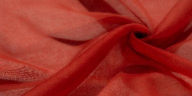 Bulanık kırmızı kumaş yumuşak, dalgalarla kaplanmış. Materyalin pürüzsüz dokusu ve şeffaf kalitesi havadar ve zarif bir estetik yaratıyor. Yaratıcı kompozisyonlar için mükemmel..