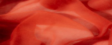 Canlı kırmızı kumaş bulanıklığı soyut ve akışkan bir desen oluşturuyor. Yumuşak, şeffaf dokusu tasarıma hafif ve havadar bir his katıyor. Tekstil arka planları ya da moda kompozisyonları için ideal..