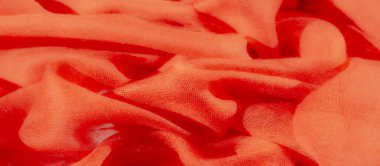 Dalgalı kırmızı kumaştan bulanık, narin kıvrımlı, yumuşak, ortam aydınlatmasıyla aydınlatılmış. Kumaşın soyut düzenlenmesi dinamik bileşime ve hareket duyusuna eklenir..