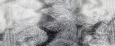 Bulanık beyaz ve gri örülmüş kumaş kaplaması yumuşak, iç içe geçmiş bir doku sergiliyor. Yumuşak lifler birbirine karışarak, iç tasarım projeleri için sakin ve estetik bir ideal oluşturuyor..