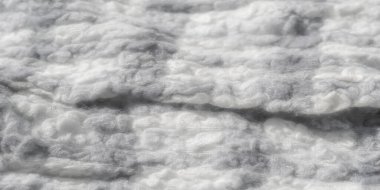 Gri tonlu kumaş deseni bulanıklığı, dokuma liflerinin ince karmaşıklığını yakalıyor. Yumuşak, kabarık dokusu ışığın ve gölgenin etkileşimiyle gelişir.,