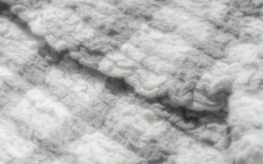 Tüylü dokusu ve ince lif detaylarıyla dokunmuş gri ve beyaz bir kumaşın bulanıklığı. Tarafsız tonlar ve yumuşak görünüm görüntüye sıcak, rahat bir his veriyor, kumaş tasarımı için mükemmel.