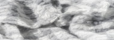 Bulanık desenli gri derili ve beyaz kumaşlı yumuşak, detaylı örgü örüyor. Görüntü karmaşık desenleri ve lif dokularını vurgular, zarif, kabarık ve samimi bir görünüm verir..