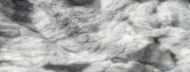 Yumuşak gri pulları ve beyaz kumaş dokularını bulanıklaştırarak birbirine dolanmış liflerin karmaşık detaylarını yakalıyor. Yakından bakınca, narin ve bulanık bir görünüm ortaya çıkıyor, rahat bir ortam yaratıyor.