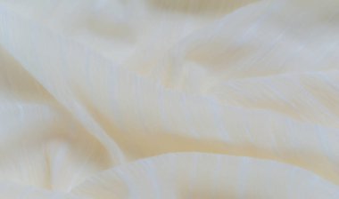 Kumaş, yumuşak dalgalanmalar ve yumuşatıcı bir doku yaratan ince sarı bir ton sergiliyor, her ayara zarafet ve sakinlik katmak için mükemmel..