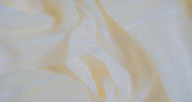 Görüntü. Yumuşak beyaz çizgili hafif sarı kumaş. Nazikçe katlanmış. Kumaşın hassas dokusu ve ince parıltısı parlak, havadar bir etki yaratır. Zarif tasarımlar için mükemmeldir..