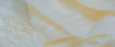 Görüntü. Pürüzsüz, hafif, beyaz çizgili ve hafif parıltılı sarı bir kumaş. Katlar akışkan, dinamik bir doku yaratır. Zarif ve havadar görünümünü güçlendirir..