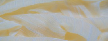 Bulanık sarı kumaş, gösterişli desenli dalgalar ve ince beyaz çizgiler. Kumaş yumuşak bir şekilde örtülür, sıcak ve doğal bir parıltıyı yansıtır. Pürüzsüz ama dokulu yüzeyi kumaşa hafif bir ağırlık verir.