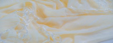 İnce kıvrımlı ve soluk çizgili bulanık sarı kumaş, ruhani ve ışıltılı bir etki yaratıyor. Kumaşın pürüzsüz yüzeyi ve hafif dokusu ışığı nazikçe yakalar ve davetkar bir davet yaratır.