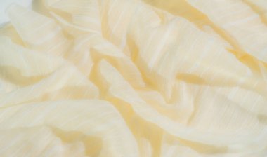 Yumuşak dalgalı açık sarı kumaş ve karmaşık gümüş iplikler. Dokuların ve ipliklerin etkileşimi soyut ve dekoratif temalar için mükemmel sakin, minimalist bir görünüm yaratır.