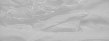 Yumuşak, beyaz kumaştan ince kıvrımlı ve ince bir dokusu var. Nazik dalgalanmalar soyut bir şablon oluşturur. Bu da onu arka plan ya da görsel öğeler için mükemmel kılar..
