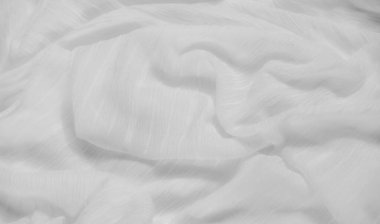 Yumuşak dalgalı ve dokulu beyaz kumaş bulanıklığı. Dalgalanan kıvrımlar, tasarım ve tekstil projelerinde asgari ve soyut kompozisyonlar için mükemmel bir sakinlik ve zarafet hissi yaratıyor.