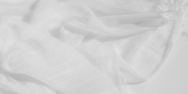 Yumuşak kıvrımları, yumuşak dokusu ve ince kırışıklıkları olan bulanık beyaz kumaş. Minimalist estetik, ışık ve gölgenin etkileşimiyle güçlenir, pürüzsüz ve sakinleştirici bir görünüm yaratır..