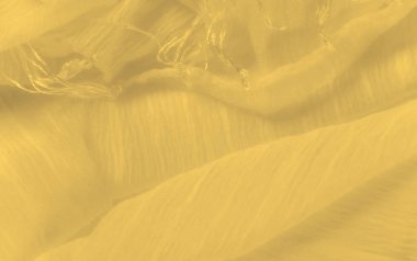 Sarı kumaş bir dizi yumuşak kıvrımlar ve çıkıntılar oluşturarak maddeye akışkan ve dinamik bir görünüm verir. Yumuşak dokusu ve narin yüzeyi hareket ve zarafet hissi uyandırıyor..