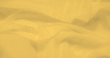 Dalgalanan kıvrımları olan parlak sarı bir kumaş ve ışığı zarif bir şekilde yakalayıp hareket hissi veren pürüzsüz, narin bir doku..
