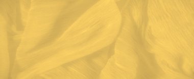 Karmaşık kıvrımları ve ince dokuları olan parlak sarı bir kumaşın bulanıklığı yüzeyinde ince bir ışık ve gölge oyunu göstererek derinlik ve hareket yaratır..