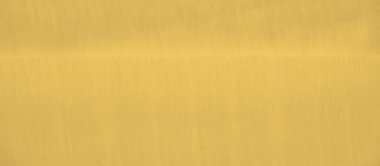 Yumuşak kıvrımları ve pürüzsüz bir yüzeyi olan parlak sarı bir kumaşın bulanıklığı. Işığı nazikçe yakalıyor ve karmaşık çizgiler ve ince gölgeler oluşturuyor..