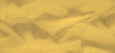 Bulanık sarı kumaş, yüzeyinde hafif dalgalanmalar olan dalga benzeri bir hareket yaratıyor. Yumuşak, güneşli doku ışığı yakalar, kumaşın pürüzsüz ve zarif akışını güçlendirir..