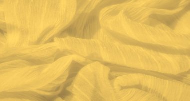 Bulanık sarı kumaş nazikçe katlanmış yumuşak dokusunu ve parlak tonunu sergiliyor. Pürüzsüz madde zahmetsizce akar ve ince kırışıklıklarla güneşin öptüğü bir görünüm yaratır..