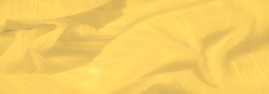 Belirgin kıvrımlı, bulanık sarı kumaş ve yumuşak ışıkla aydınlatılmış, tırtıklı bir doku. Kumaşın akışkan dizilişi zarif ve sıcak bir görsel izlenim yaratıyor..