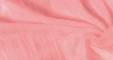 Yumuşak pastel pembe kumaştan bulanık. Yumuşak kıvrımları ve pürüzsüz bir dokusu var. Kumaş ışığı zarifçe yansıtır, akışkan ve zarif görünümüne ince bir parıltı ekler..