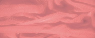 Görüntü. Karmaşık dokusu olan açık mercan kumaşı yumuşak ve akışkan bir desen oluşturur. Zarif kumaş ve ince titreşimli iplikler rahatlatıcı ve zarif bir görünüm yaratır.