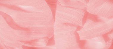 Yumuşak şeftali rengi kumaşın bulanık kıvrımları ve yumuşak bir dokusu var. Kırışıklıklar ve pastel renkler rahatlatıcı ve zarif bir estetik yaratıyor..