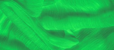 Karmaşık ipliklerle örülmüş canlı yeşil kumaş bulanıklığı pürüzsüz yüzeyindeki yumuşak ışık yansımalarıyla güçlendirilmiş dokulu bir tasarım yaratıyor..