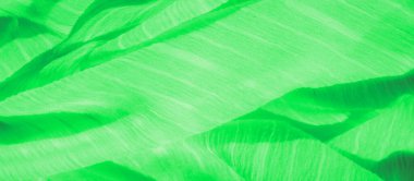 Görüntü: Canlı, yeşil bir kumaş, kıvrımları akan ve ince iplikçikler oluşturan, dokulu, parlak bir yüzey. Modern estetik ile çevre dostu ve organik tasarım temaları için ideal..