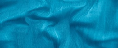 Yumuşak iç içe geçmiş kıvrımları olan canlı mavi kumaş bulanıklığı, hareket ve doku hissi ekliyor. Nazikçe katlanmış malzeme karmaşık detaylarla dinamik bir görsel akış yaratır..