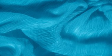 Dalgalı dokuma desenli parlak mavi kumaş bulanıklığı. Kumaşın dinamik akışı ve ipliklerin karmaşık detayları büyüleyici bir karşıtlık yaratır..