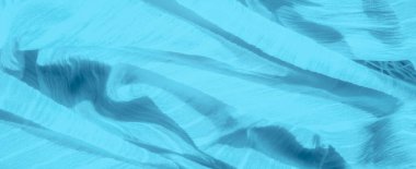 Yumuşak dokudan çıkan ince, dağınık ipliklerle mavi kumaş bulanıklığı pürüzsüz ve akıcı arka planla çelişen karmaşık ve dinamik bir görsel etki yaratır..