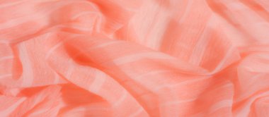 Yumuşak mercan kumaşından bulanık ışık, katıksız doku ve ince çizgiler. Katlar akışkan ve dalgalı bir görünüm yaratıyor, narin ve şeffaf materyali vurguluyor..