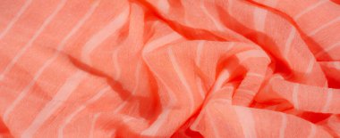 Bulanık, yumuşak turuncu kumaş, yumuşak beyaz çizgili, pürüzsüz kıvrımlı, karmaşık bir örtü sergiliyor. Işığın ve gölgenin hassas etkileşimi kumaşın tasarımına derinlik ve doku ekler..