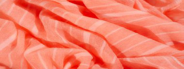 Bulanık, yumuşak turuncu kumaş, yumuşak beyaz çizgili, pürüzsüz kıvrımlı, karmaşık bir örtü sergiliyor. Işığın ve gölgenin hassas etkileşimi kumaşın tasarımına derinlik ve doku ekler..