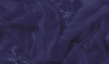 Yumuşak mavi kumaş yumuşak dalgalar halinde akar, dokulu yüzeyde akan ışık çizgileriyle güçlenir. Kumaşın narin görünüşü bir lüks ve sakinlik hissi uyandırıyor..