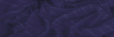 İnce parlak dokuları ve yumuşak dalgalı kıvrımları olan koyu mavi kumaş bulanıklığı. Kumaşın ipeksi görünüşü soyut ve tasarım için mükemmel bir derinlik ve nazik hareket hissi yaratır..