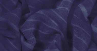 Dalgalı, yumuşak kıvrımlı, parlak bir yüzeyi olan zengin mavi kumaş bulanıklığı. Koyu mavi renk derinlik ve zarafet ekler, görsel olarak soyut bir doku yaratır.
