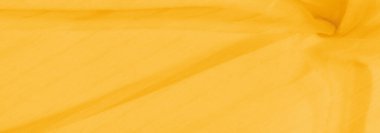 Yumuşak kıvrımlı, pürüzsüz sarı kumaştan oluşan bir bulanıklık, sakin ve akışkan bir görüntü yaratıyor. Kumaşın hafif dokusu hareketi yakalar ve canlı sarı tonlara derinlik katar..